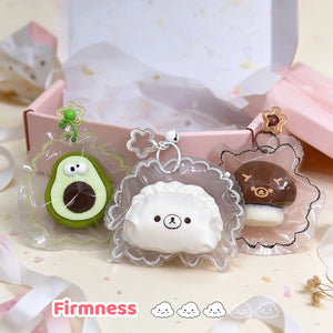 Green avocado, brown mushroom, and white dumpling squishy charms arranged together.