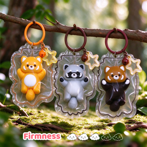 Three raccoon-shaped squishy charms hanging together outdoors.