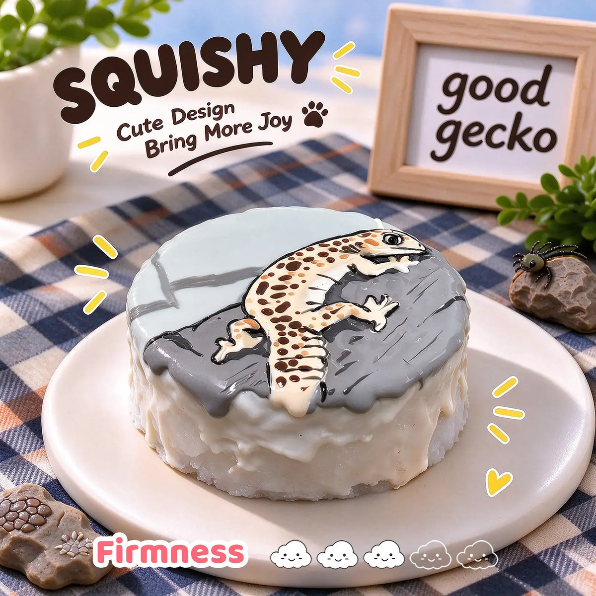 Leopard gecko squishy side view, round gray and cream squishy with hand-painted leopard gecko rock-climbing design, soft glossy silicone texture, thick cake-like side profile, blue-brown checkered table setting, wooden "good gecko" sign and tiny spider decoration in background