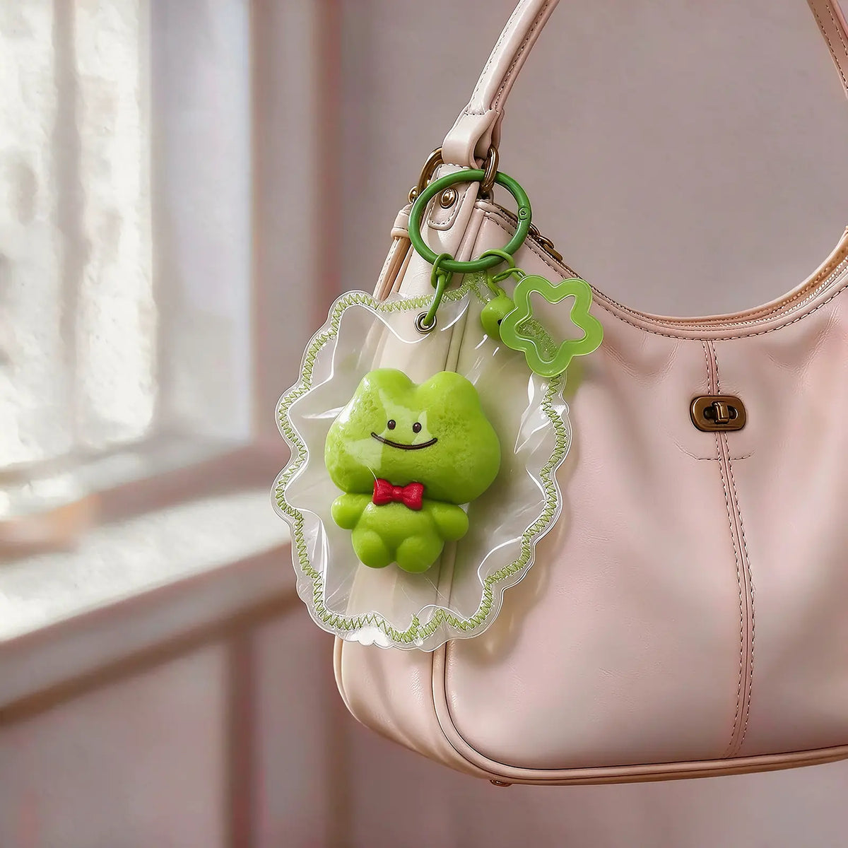 Green frog-shaped squishy charm hanging from a handbag.