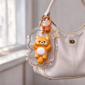 Raccoon-shaped squishy bag charm shown in a close-up accessory photo.