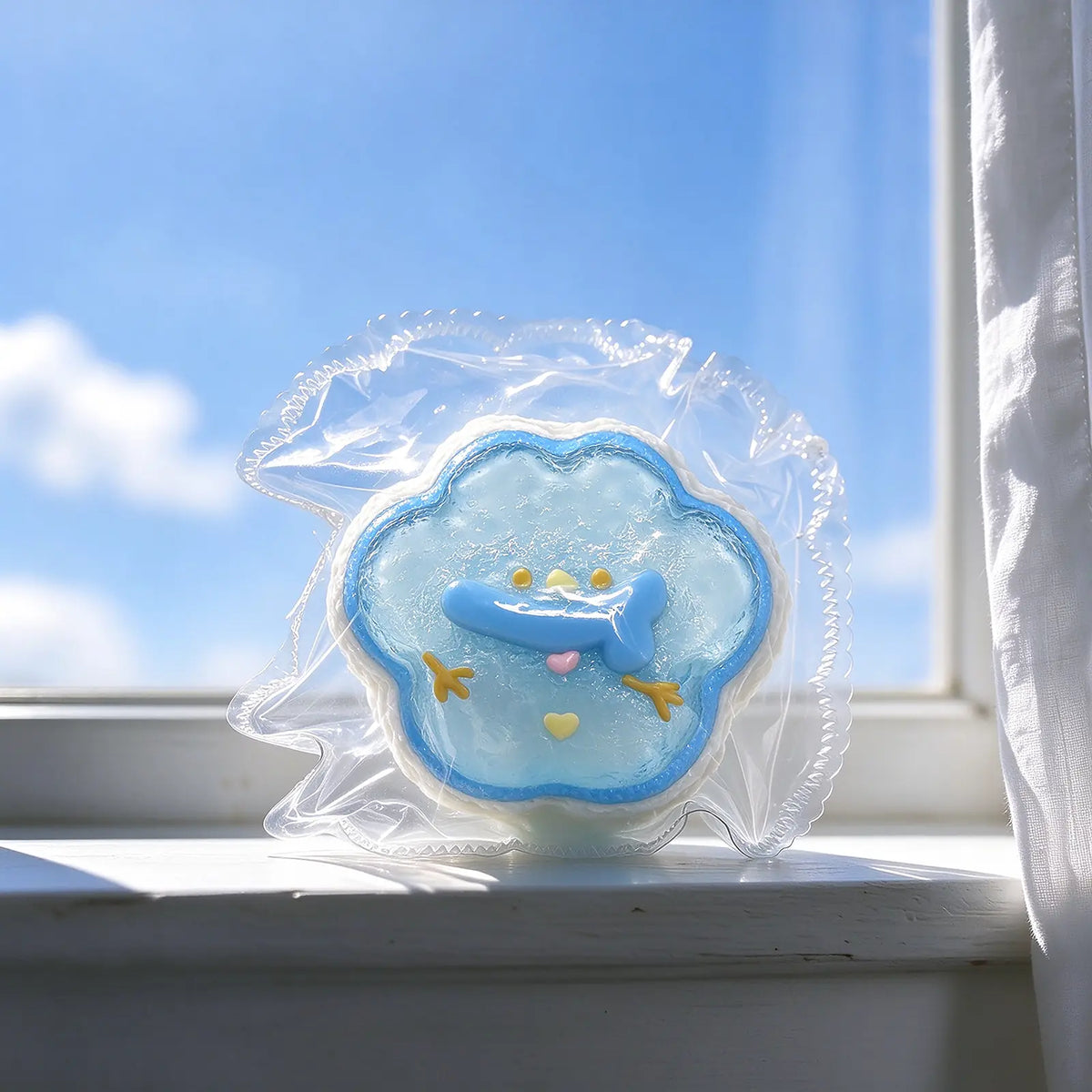 Blue frosted snowman squishy displayed on a bright windowsill.