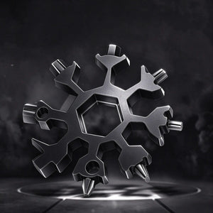 Gift FlakeWrench snowflake multi-tool, matte black metal snowflake shaped wrench with hex sockets and screwdriver tips, all-in-one portable EDC tool on dark moody background