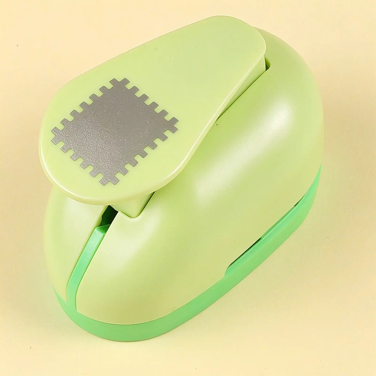 Green puzzle punch gift tool, light green plastic paper punch with metal puzzle-edge cutting die, craft punch for making custom puzzle pieces