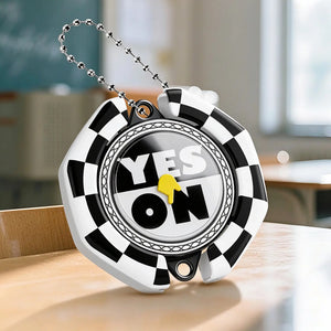 Gift SpinCall decision spinner keychain, black and white checkerboard YES NO fidget spinner with metal ball chain, portable decision making key charm placed on wooden classroom desk