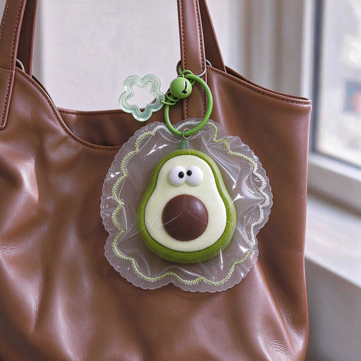 Green avocado-shaped squishy with a simple face displayed as a product charm.