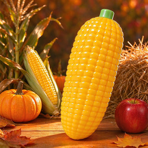 Yellow corn-shaped squishy displayed in a warm kitchen scene beside autumn produce.