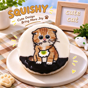Hand-painted Scottish Fold squishy toy, cute Scottish Fold cat portrait on soft round fidget toy, light cream glossy surface with orange tabby markings and green ruffle collar design