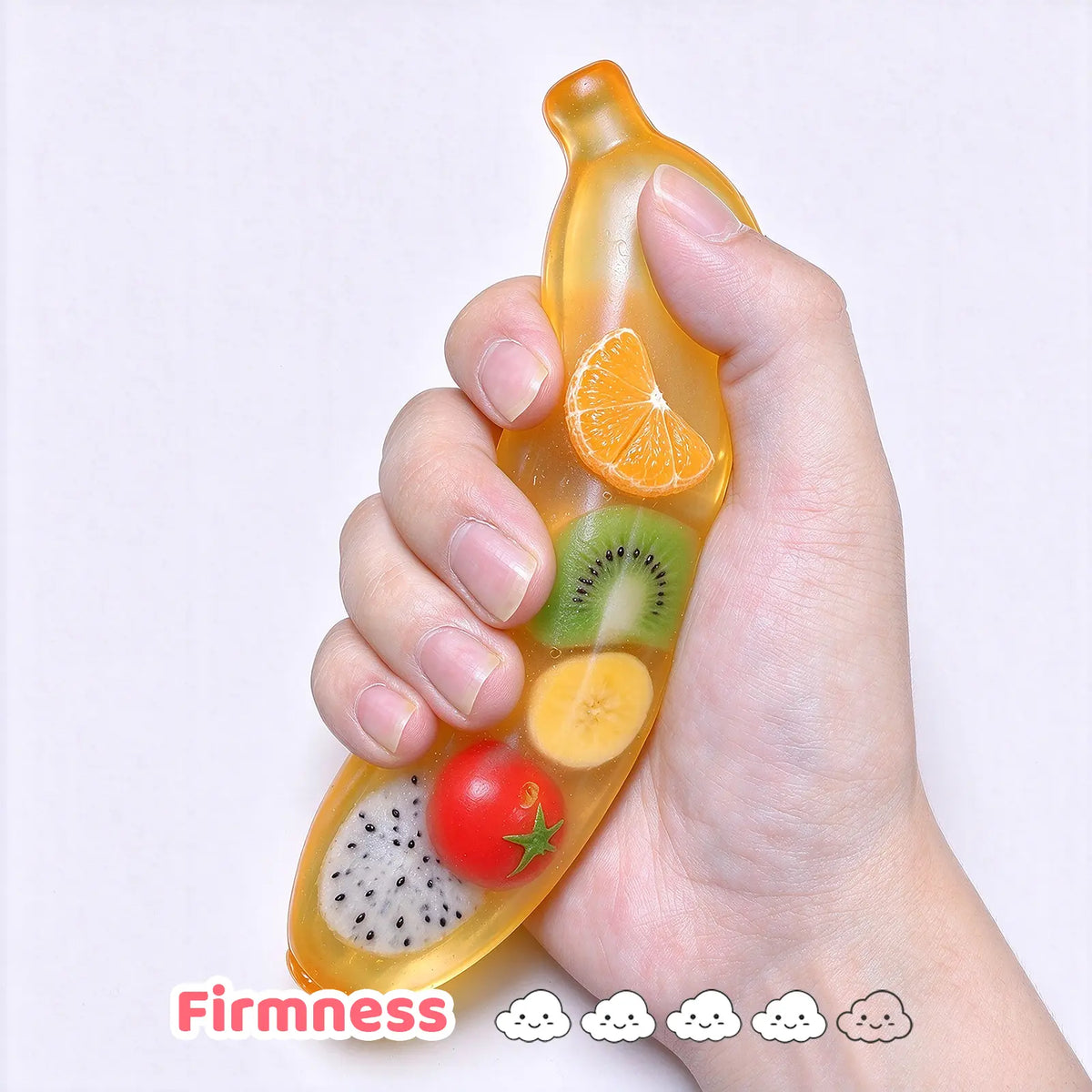 A hand holding a transparent banana-shaped squishy filled with colorful fruit pieces.