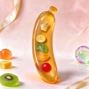 Close-up of a transparent banana-shaped squishy with colorful fruit pieces inside.
